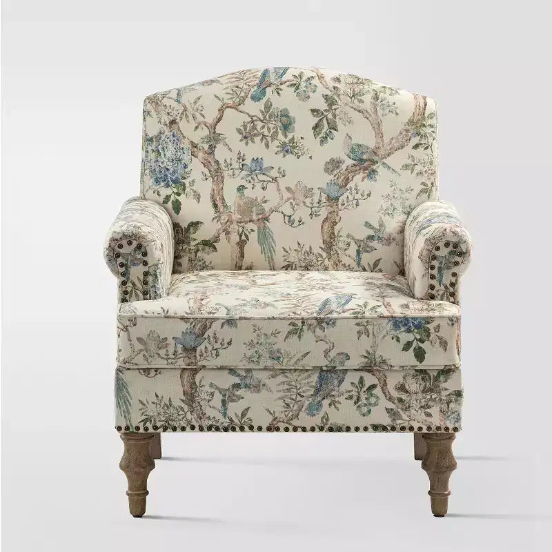 Fauteuil rembourré en bois avec motif floral, accoudoirs à panneaux et dossier en forme de bosse de chameau.